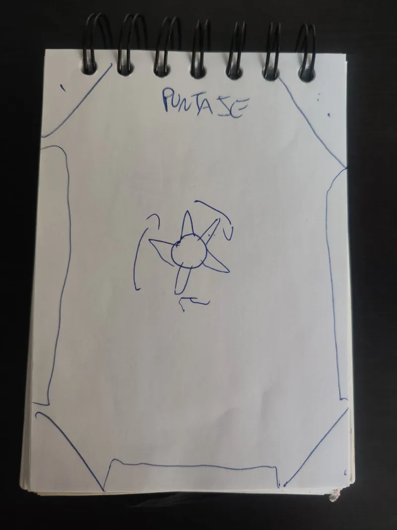 Segundo boceto a tinta azul con el puntaje arriba, las esquinas recortadas y una figura con pinchos girando en el centro.